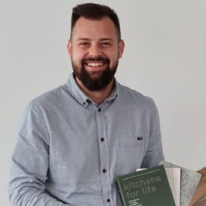 Mariusz Bartczak mit verschiedenen Heften und Beispiel Mustern in der Hand