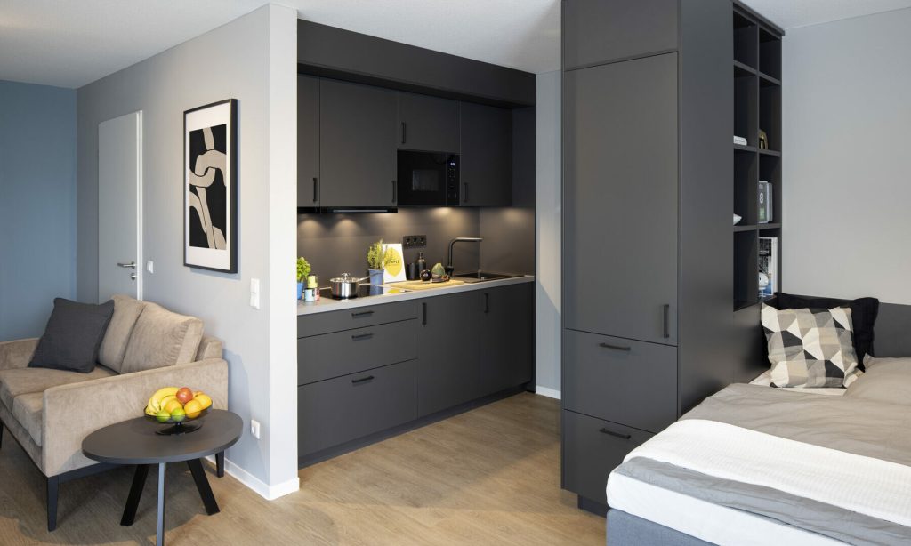 Apartment mit dunkler Küchenzeile und Bett – Düsseldorf – Himmelgeister Höfe