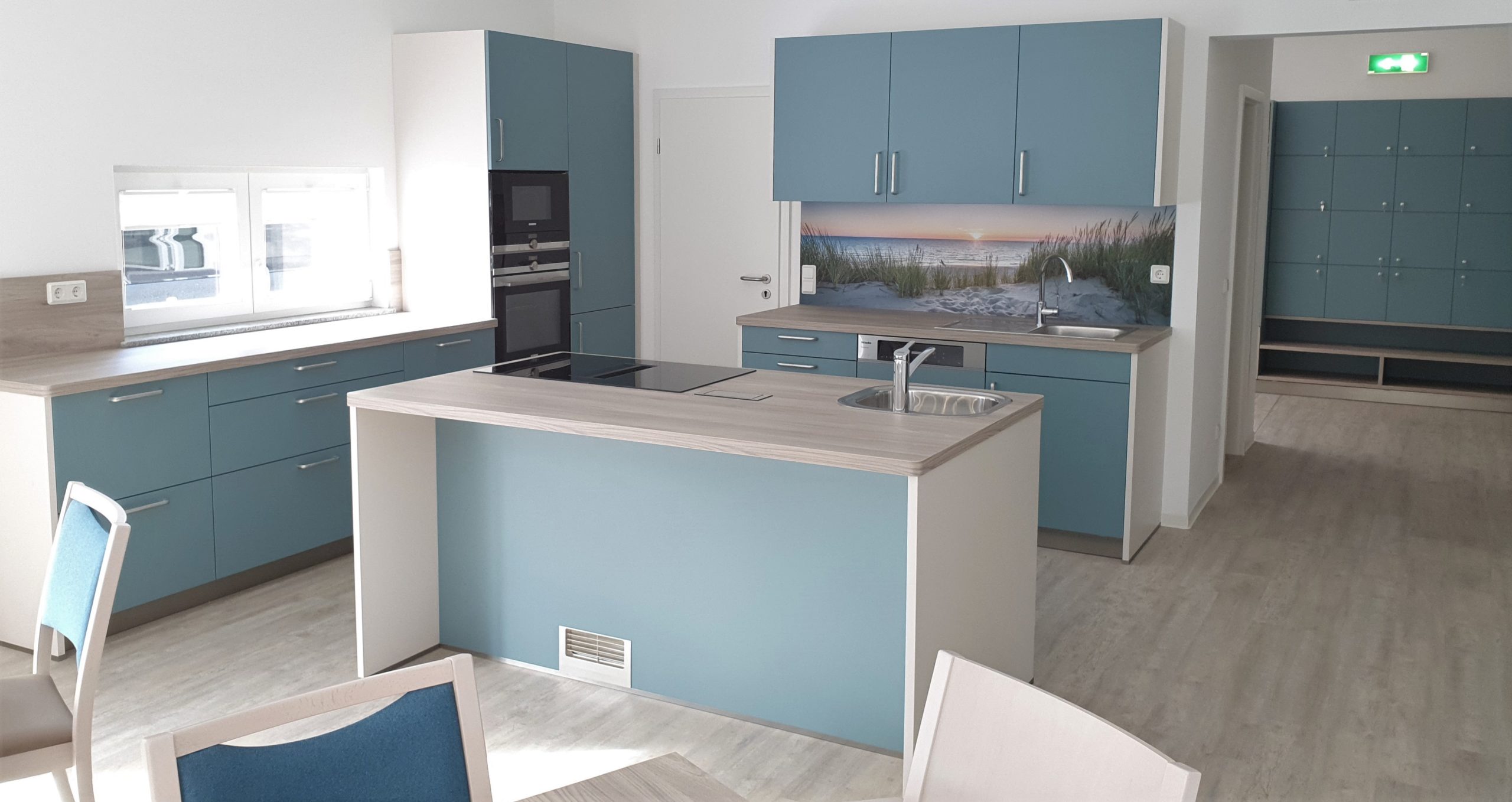 Küchenbereich mit blauen Fronten und Kücheninsel