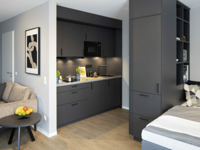 Schwarze Küche mit einem Schrank und einem Bett