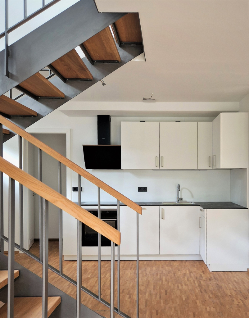 Weiße Küchenzeile unter einer Treppe – Dresden – Quartier Dresden-Neustadt