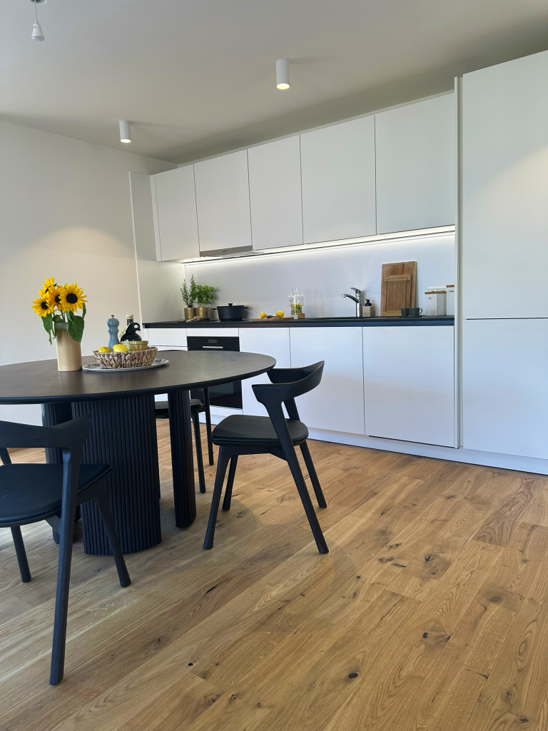 Weiße Küche mit schwarzem Tisch und schwarzen Stühlen – Hohenems – Rathausquartier