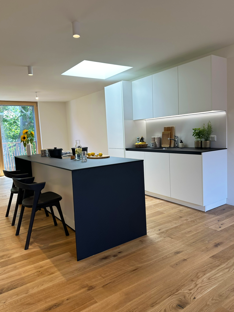 Weiße Küche mit schwarzem Tisch – Hohenems – Rathausquartier
