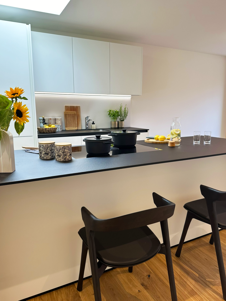 Weiße Küche mit schwarzem Tisch – Hohenems – Rathausquartier