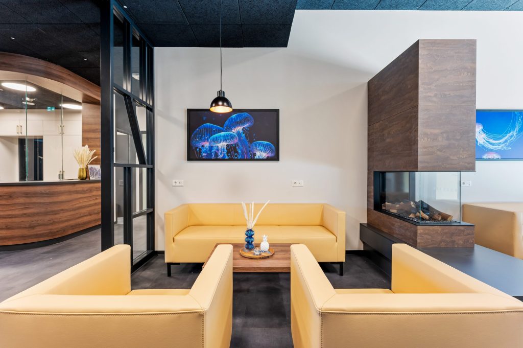 Lounge mit gelben Sofas und Kamin – Eschborn – Campo Novo Aparthotel