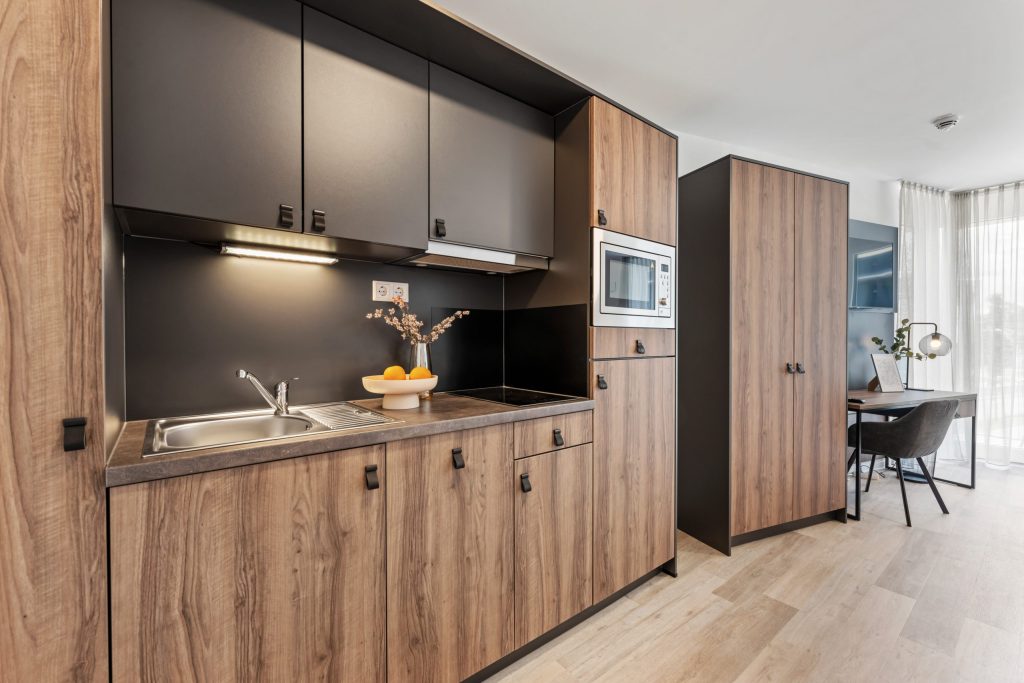 Küchenzeile mit Holzfronten und Mikrowelle – Stuttgart-Vaihingen – Campo Novo Aparthotel