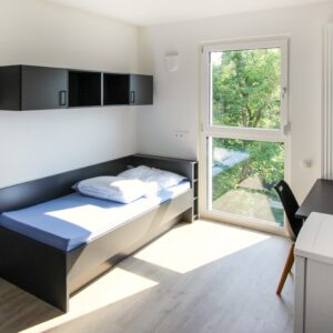 Schlafzimmer mit einem schwarzen Bett und Schränken