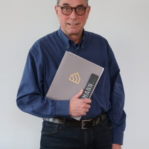 Jochen Schäufele mit einem Heft und einem Zollstock in der Hand