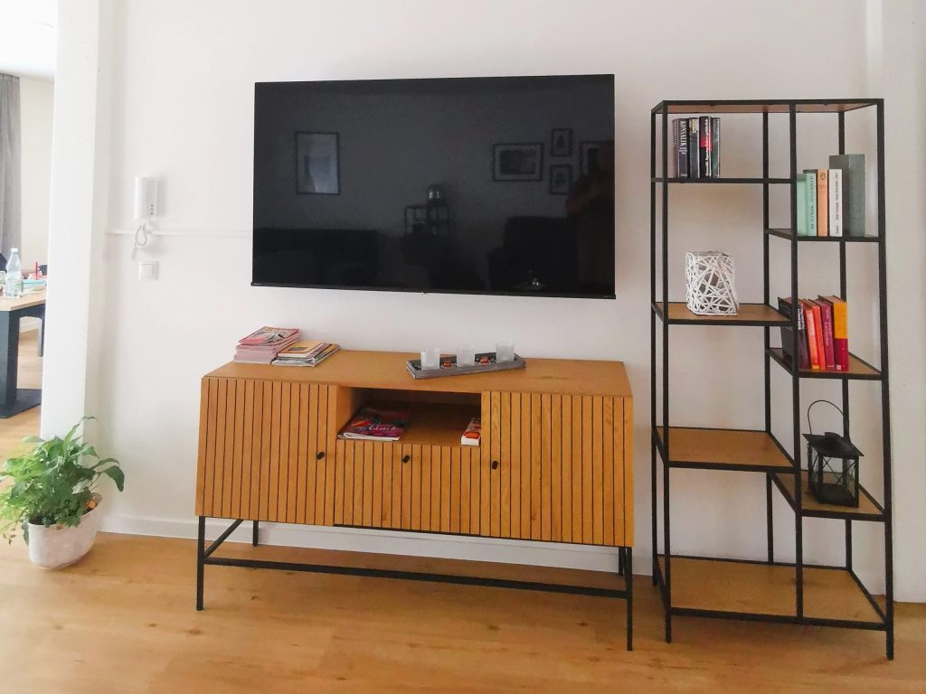 Living area with a TV and shelving – Nordhorn – Neuberliner Hof Residential Community